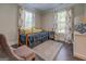 Cozy bedroom with neutral walls, dark hardwood floors, floral curtains, and area rug at 1461 Thomas St, Conyers, GA 30094