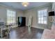 Spare bedroom with dark hardwood floors, two large windows, modern light fixture, and minimal furniture at 1461 Thomas St, Conyers, GA 30094