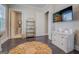 Bedroom featuring dark wood floors, area rug, view to bathroom and built in shelves and a mounted TV at 1461 Thomas St, Conyers, GA 30094