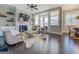 Cozy living room with a fireplace, ceiling fan, large windows, and hardwood floors at 1461 Thomas St, Conyers, GA 30094