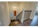 Wood stairway featuring white pillars, black railings, a hanging pendant light and artwork on the wall at 1461 Thomas St, Conyers, GA 30094