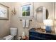 Charming powder room with a navy blue vanity, gold fixtures, and natural light from the window at 240 Trotters Rdg, Fayetteville, GA 30215