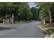 Neighborhood entrance featuring a white fence and landscaped median on a paved road at 240 Trotters Rdg, Fayetteville, GA 30215