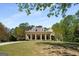 Charming traditional home with a large front lawn, mature trees, a covered front porch, and a circular drive at 240 Trotters Rdg, Fayetteville, GA 30215