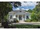 Charming white home exterior with a welcoming front porch and meticulously landscaped front yard and mature trees at 240 Trotters Rdg, Fayetteville, GA 30215