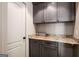 Functional laundry area with gray cabinets, granite countertop, and vertical wood paneling at 240 Trotters Rdg, Fayetteville, GA 30215