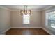 Dining room with hardwood floors, modern light fixture and bright double windows at 3164 Harris Dr, East Point, GA 30344