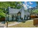 Quaint cottage with blue door, white brick chimney, mature shade trees, and a carport at 3164 Harris Dr, East Point, GA 30344
