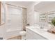 Bright bathroom features a tub with shower and a modern sink with decorative artwork, enhanced by wood-look flooring at 1020 Sutherland Lane # 41, Lawrenceville, GA 30043