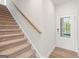 A bright entryway with a wood-look floor, a glass-paneled door, and carpeted stairs with a light wood handrail at 1020 Sutherland Lane # 41, Lawrenceville, GA 30043