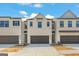 A modern townhome with a two car garage and neutral color scheme on a partially cloudy day at 1020 Sutherland Lane # 41, Lawrenceville, GA 30043