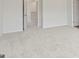 A large bedroom with neutral carpet and white walls leading to an upstairs hallway at 1020 Sutherland Lane # 43, Lawrenceville, GA 30043