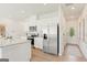 Open-concept kitchen featuring stainless steel appliances, white cabinets, and an adjacent dining area with front door at 1028 Sutherland Lane # 45, Lawrenceville, GA 30043