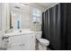 Functional bathroom with white vanity, toilet, and shower with a dark curtain for privacy at 12843 Simmons Rd, Hampton, GA 30228