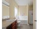 Bright bathroom features a soaking tub with shower and a single sink vanity with dark wood cabinets at 7756 Newbury Dr, Jonesboro, GA 30236