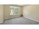Bedroom with natural light streaming through the window, neutral walls, and plush carpeting at 7756 Newbury Dr, Jonesboro, GA 30236