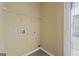 Clean laundry room features connections for a washer and dryer, plus a metal shelving unit at 7756 Newbury Dr, Jonesboro, GA 30236