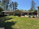 Lush backyard featuring a well-maintained lawn, pool, patio seating, and mature trees at 363 Palmetto Rd, Tyrone, GA 30290