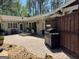 The backyard patio features stone detail, a bench, potted plants, and a grill at 363 Palmetto Rd, Tyrone, GA 30290