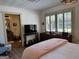 Bright bedroom with wood floors, shutters, TV and adjacent bathroom at 363 Palmetto Rd, Tyrone, GA 30290