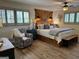 Bedroom featuring custom headboard, wood floors, and patterned chair at 363 Palmetto Rd, Tyrone, GA 30290