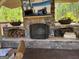 An outdoor fireplace features firewood storage on one side and a mantle with planters on the other at 363 Palmetto Rd, Tyrone, GA 30290