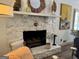 Close-up of the stone fireplace with decorative mantel, accessories, and artwork in a well-lit living space at 363 Palmetto Rd, Tyrone, GA 30290
