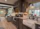 Charming kitchen with dark cabinets, stone farmhouse sink, granite countertops, and stainless steel appliances at 363 Palmetto Rd, Tyrone, GA 30290