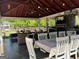 A covered outdoor space with a stone fireplace, tv, dining table and seating offer great entertainment space at 363 Palmetto Rd, Tyrone, GA 30290