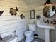 Close-up of an outhouse interior showcasing the toilet, sink, mirror, and decorations at 363 Palmetto Rd, Tyrone, GA 30290