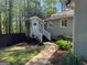 View of the rear exterior featuring a gray house with a small outhouse connected by a walkway at 363 Palmetto Rd, Tyrone, GA 30290