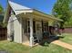 The exterior view of the shed features a covered porch with seating, American flag, and garden at 363 Palmetto Rd, Tyrone, GA 30290