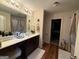 Bright bathroom featuring double sinks, great lighting, framed mirrors, and a door to a walk-in closet and toilet at 6539 Saint Mark Way, Fairburn, GA 30213
