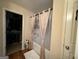 Bright bathroom with tub and shower combination featuring tan curtains and a decorative vase at 6539 Saint Mark Way, Fairburn, GA 30213