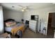 Neutral bedroom featuring a bed, ceiling fan, a TV on a silver chest, and a doorway with a peek into the en suite bathroom at 6539 Saint Mark Way, Fairburn, GA 30213