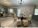 Dining area features a modern glass table, seating for six, and bright natural lighting at 6539 Saint Mark Way, Fairburn, GA 30213