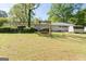 Spacious backyard featuring a swing set and shed with a well-manicured lawn and lush greenery at 30 Circle Dr, Hampton, GA 30228