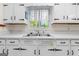 Close up of a kitchen featuring a stainless steel sink and white cabinets and vintage hardware at 30 Circle Dr, Hampton, GA 30228