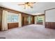 Spacious living room features wood paneling, large windows, and a classic ceiling fan with lighting at 30 Circle Dr, Hampton, GA 30228