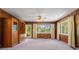 Large living room featuring wood paneling, neutral carpeting, and natural light from the sliding glass doors at 30 Circle Dr, Hampton, GA 30228