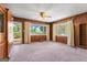 Large living room featuring wood paneling, neutral carpeting, and large windows looking out onto the water at 30 Circle Dr, Hampton, GA 30228