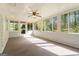Bright sunroom with walls of windows, neutral carpeting, and a ceiling fan for comfortable living at 30 Circle Dr, Hampton, GA 30228