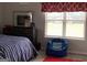 Bedroom featuring window with natural light, bed with striped bedding, and a comfy beanbag chair at 160 Elysian Dr, Fayetteville, GA 30214