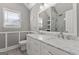 Bathroom features a double sink vanity with marble countertops, a window and a tiled shower in the mirror reflection at 421 Bear Cub Path, Social Circle, GA 30025