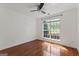 Bedroom with a ceiling fan, light walls, window and wood flooring at 421 Bear Cub Path, Social Circle, GA 30025