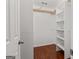 Walk-in closet with wood floors, white walls, exposed ceiling elements, and wood shelving on the right side at 421 Bear Cub Path, Social Circle, GA 30025