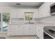 Bright kitchen with stainless steel appliances, white cabinetry and countertops, and sliding glass door at 421 Bear Cub Path, Social Circle, GA 30025