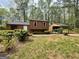 Exterior view of house featuring mature trees, bushes, and a detached carport at 862 Bridgewater Ct, Stone Mountain, GA 30088