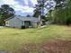 Spacious backyard featuring a well-maintained lawn, patio furniture, and an outbuilding for storage at 140 Stoneview Cir, Covington, GA 30016