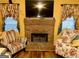 Inviting living room with a brick fireplace, comfortable chairs, and stylish curtains and wood flooring at 140 Stoneview Cir, Covington, GA 30016